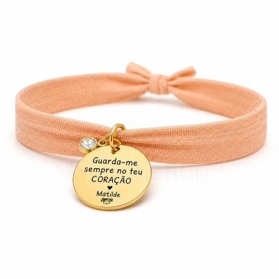 Pulseira elástica pêssego com pendente dourado gravado e pedra transparente