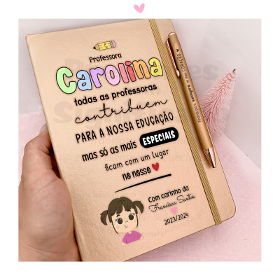Caderno dourado com texto personalizado para professora Carolina acompanhado de caneta dourada e fundo rosa com mini árvore