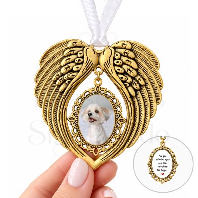 Ornamento dourado em forma de asas com moldura oval e fotografia de cão, pendurado com fita branca