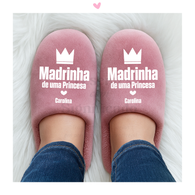 Par de pantufas cor-de-rosa com texto branco para madrinha, usadas sobre tapete branco.