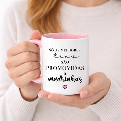 Caneca branca e rosa com texto em português, segurada por mãos femininas