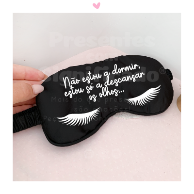 Máscara de dormir preta com texto em branco e desenho de pestanas