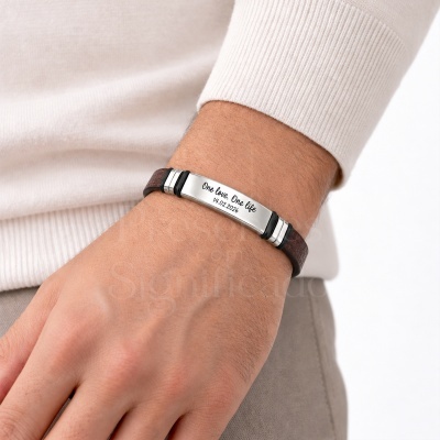Pulseira de couro castanho com placa metálica gravada usada no pulso
