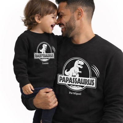 Duas pessoas vestindo camisolas pretas com estampas de dinossauros e textos personalizados.