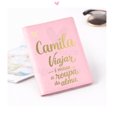 Capa de passaporte rosa com texto dourado e elementos associados a viagem