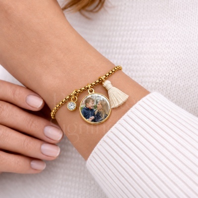 Pulseira dourada com medalhão personalizado com foto e pendentes em pulso masculino com camisola branca.