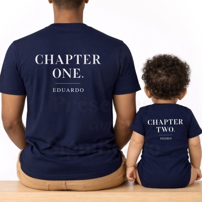 T-shirt e body azul-marinho com texto branco, vistos de costas, com pessoas sentadas num banco de madeira.