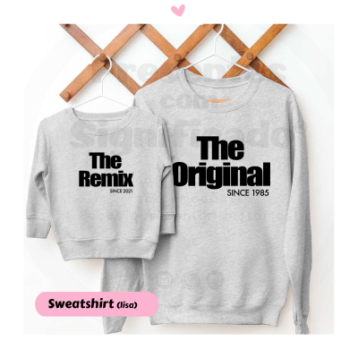 Duas sweatshirts cinzentas com textos 'The Remix SINCE 2021' e 'The Original SINCE 1985' penduradas em cabides