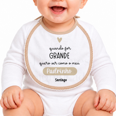 Babete branco com borda bege e texto personalizado usado por bebé