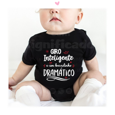 Bebé com body preto com texto em branco e vermelho sentado