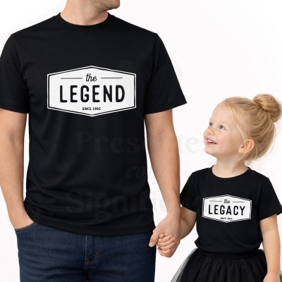 T-shirts pretas com texto branco THE LEGEND e THE LEGACY, adulto segurando mão da criança