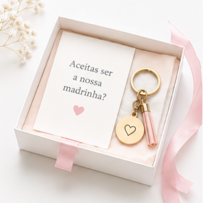 Caixa branca aberta com chaveiro dourado e cartão com texto para madrinha