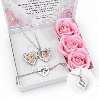 Caixa branca com conjunto de joias prateadas em forma de coração com fotos e texto, com flores rosas artificiais
