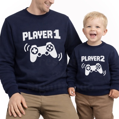 Sweats azuis escuras para homem e criança com estampa de comando de videojogo e textos PLAYER 1 e PLAYER 2.
