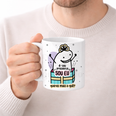 Caneca branca com ilustração colorida e texto em português, segurada por uma mão.