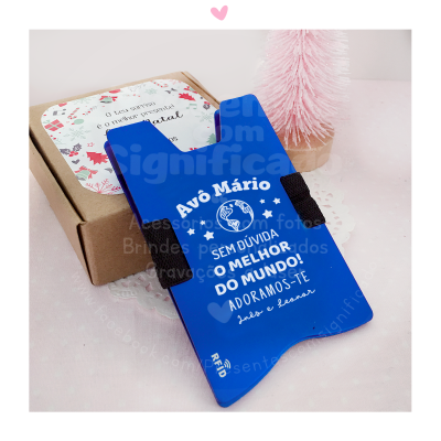 Suporte para telemóvel azul com texto e caixa de cartão com etiqueta festiva em fundo claro