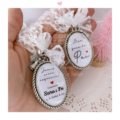 Dois porta-chaves metálicos com renda branca e textos em português para casamento.