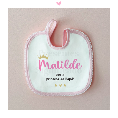 Babete de bebé branco com borda rosa e texto colorido 'Matilde sou a princesa do Papá!'