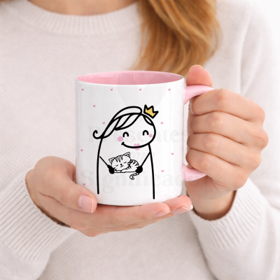 Caneca branca com interior cor-de-rosa e ilustração de figura feminina com coroa a segurar gato