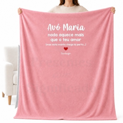Manta rosa personalizada com texto para Avó Maria, segurada por pessoa em frente a sofá branco