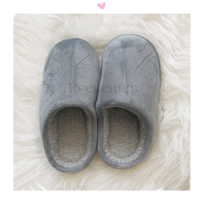 Chinelos cinzentos com interior peludo em superfície branca felpuda
