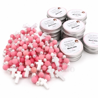 Lembranças de batismo com pulseiras rosas e latas prateadas etiquetadas
