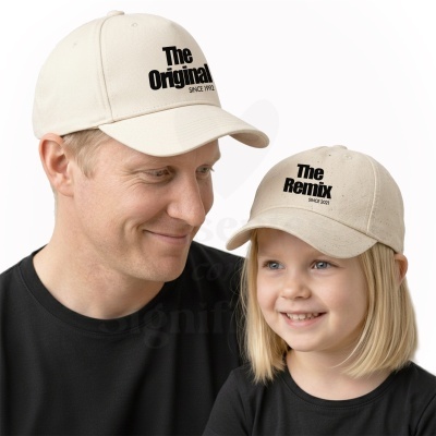 Um homem e uma menina usando bonés bege claro com texto preto e camisolas pretas.