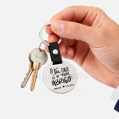 Chaveiro metálico redondo com texto em português e chaves