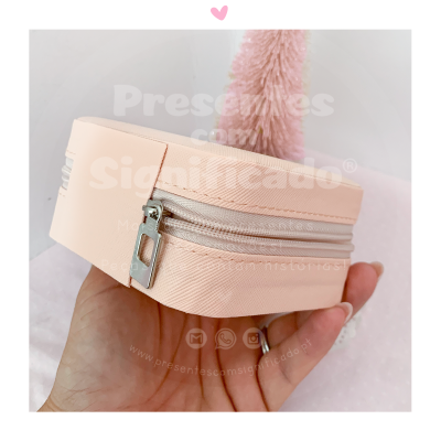 Estojo bege claro com fecho de correr prateado na mão de uma pessoa