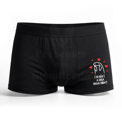 Cuecas boxer pretas com estampa de personagem caricatural e corações vermelhos com texto em português.