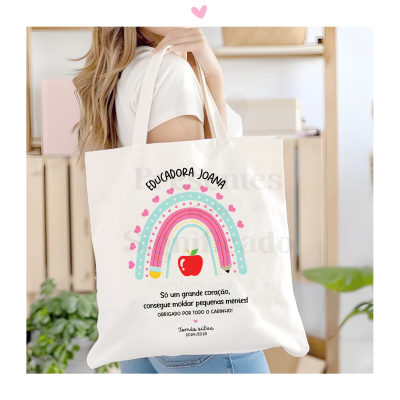 Saco de tecido branco com estampa colorida e texto personalizado em português.