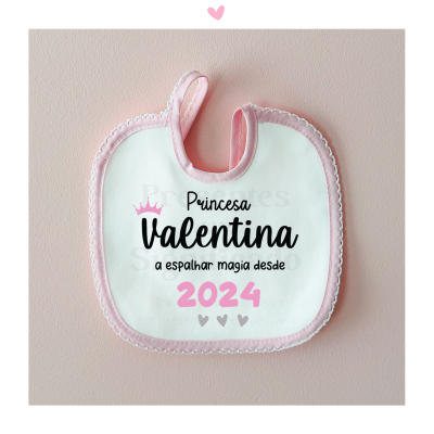 Babete de bebé branco com borda rosa e texto impresso [Princesa Valentina a espalhar magia desde 2024]