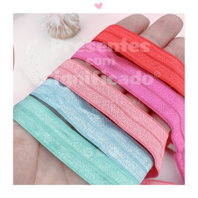 Fitas elásticas coloridas em diferentes tons seguradas por uma mão