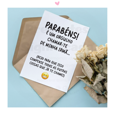 Cartão com mensagem de parabéns, envelope bege e flores secas sobre fundo azul claro