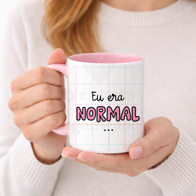 Caneca branca e rosa com texto em português, segurada por uma pessoa.