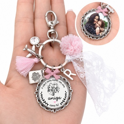 Porta-chaves com medalhão, pompons rosa, renda branca e pendentes metálicos