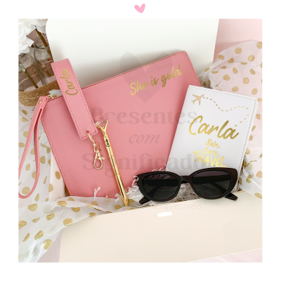 Estojo rosa com acessórios e passaporte decorativo branco com texto 'Carla live love TRAVEL'
