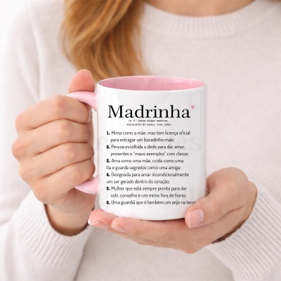 Caneca branca com texto Madrinha em português e interior rosa, segurada por mãos femininas