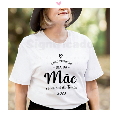 T-shirt branca com texto preto comemorativo do primeiro dia da mãe, usada por mulher ao ar livre