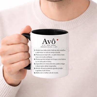 Caneca branca com interior preto e texto sobre Avô segurada por uma mão.