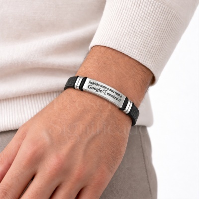 Pulseira preta com placa de metal prateada gravada, usada no pulso