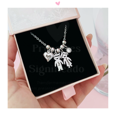 Colar prateado com pendentes de figuras humanas e coração com texto, em caixa de oferta cor de rosa.