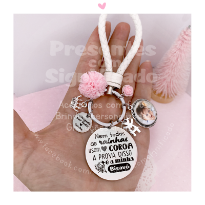 Chaveiro branco com penduricalhos metálicos e foto em fundo rosa