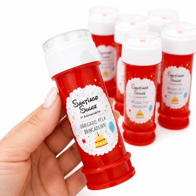 Frasco vermelho para bolhas de sabão com rótulo comemorativo de aniversário e tampa branca.
