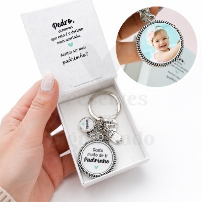 Chaveiro personalizado para padrinho em caixa branca com texto e pendentes metálicos.