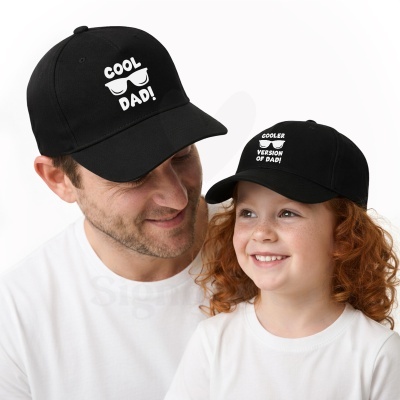 Bonés pretos com textos e desenhos de óculos usados por criança e adulto em fundo branco