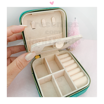 Caixa de joias verde aberta com interior bege, divisórias e fecho dourado