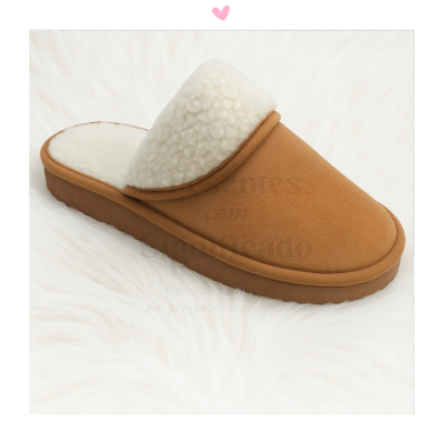 Pantufa castanha com interior em pelo branco sobre tapete branco