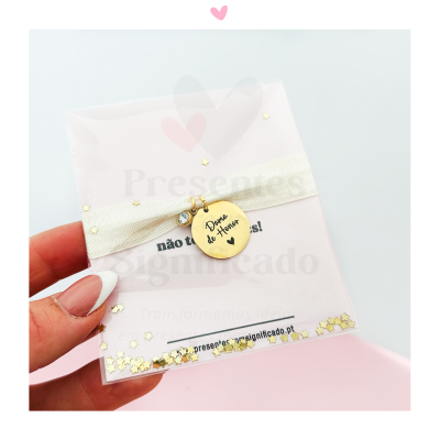 Colar com medalha dourada e embalagem com brilhos em forma de estrelas