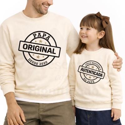 Pai e filha vestem sweatshirts creme com estampas de texto a preto e dourado com tema pai e filha.